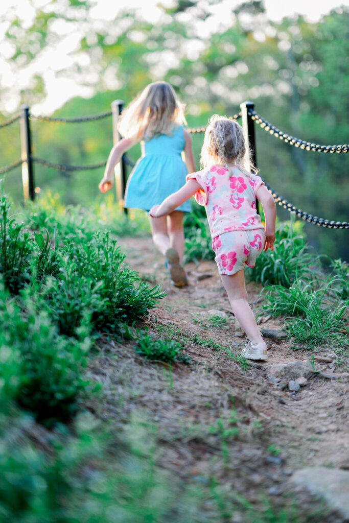 two little girls running uphill in Serenbe