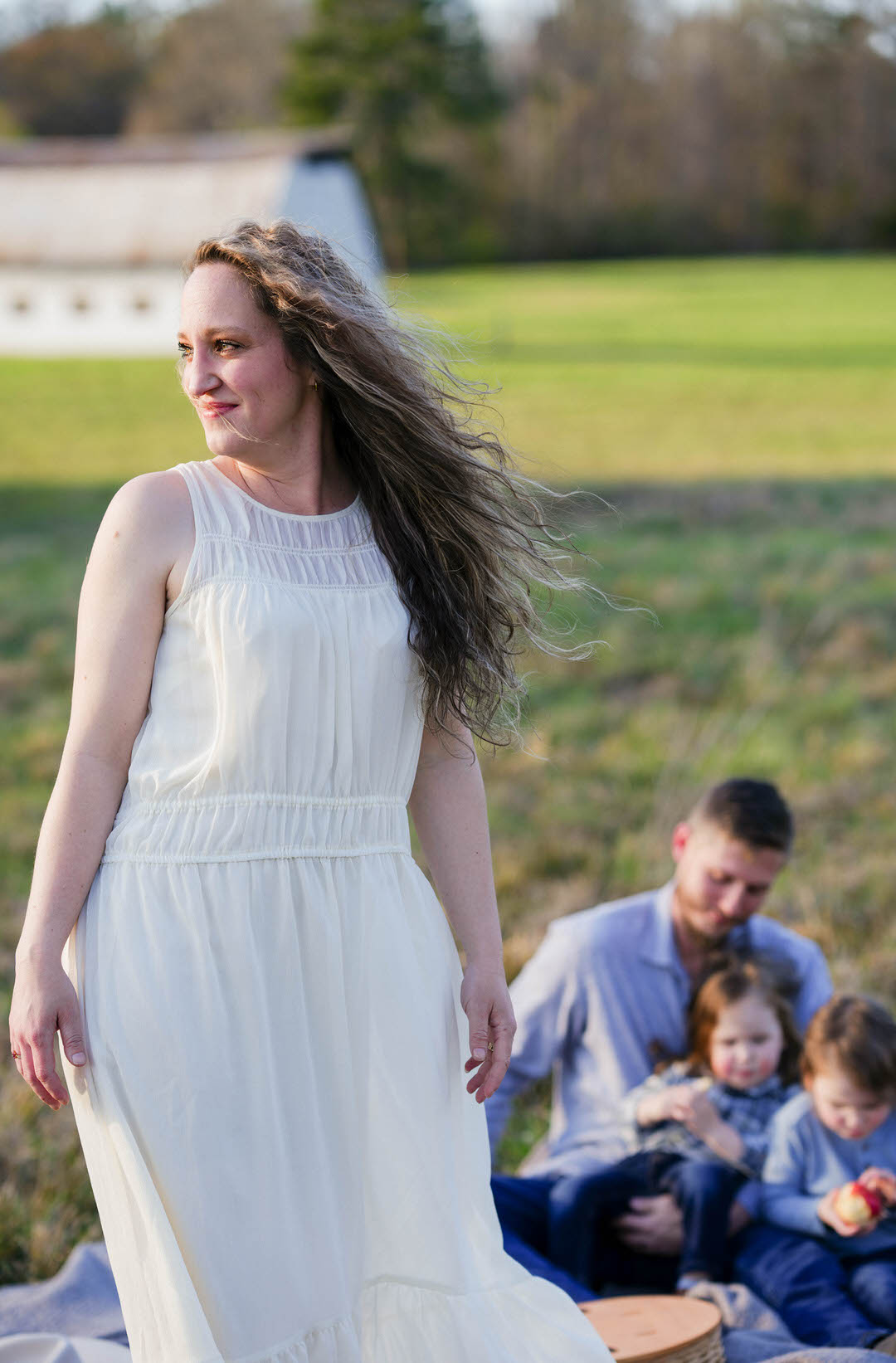 Mother standing in front of her growing family in a field