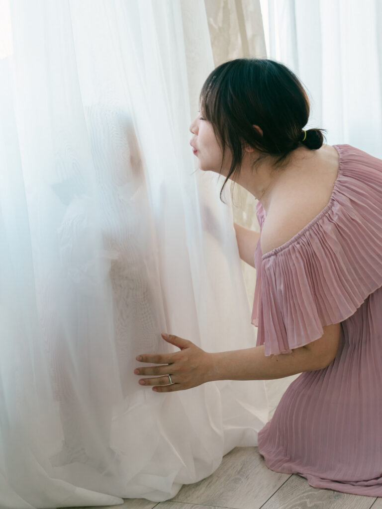 mom kissing toddler through a sheer white curtain