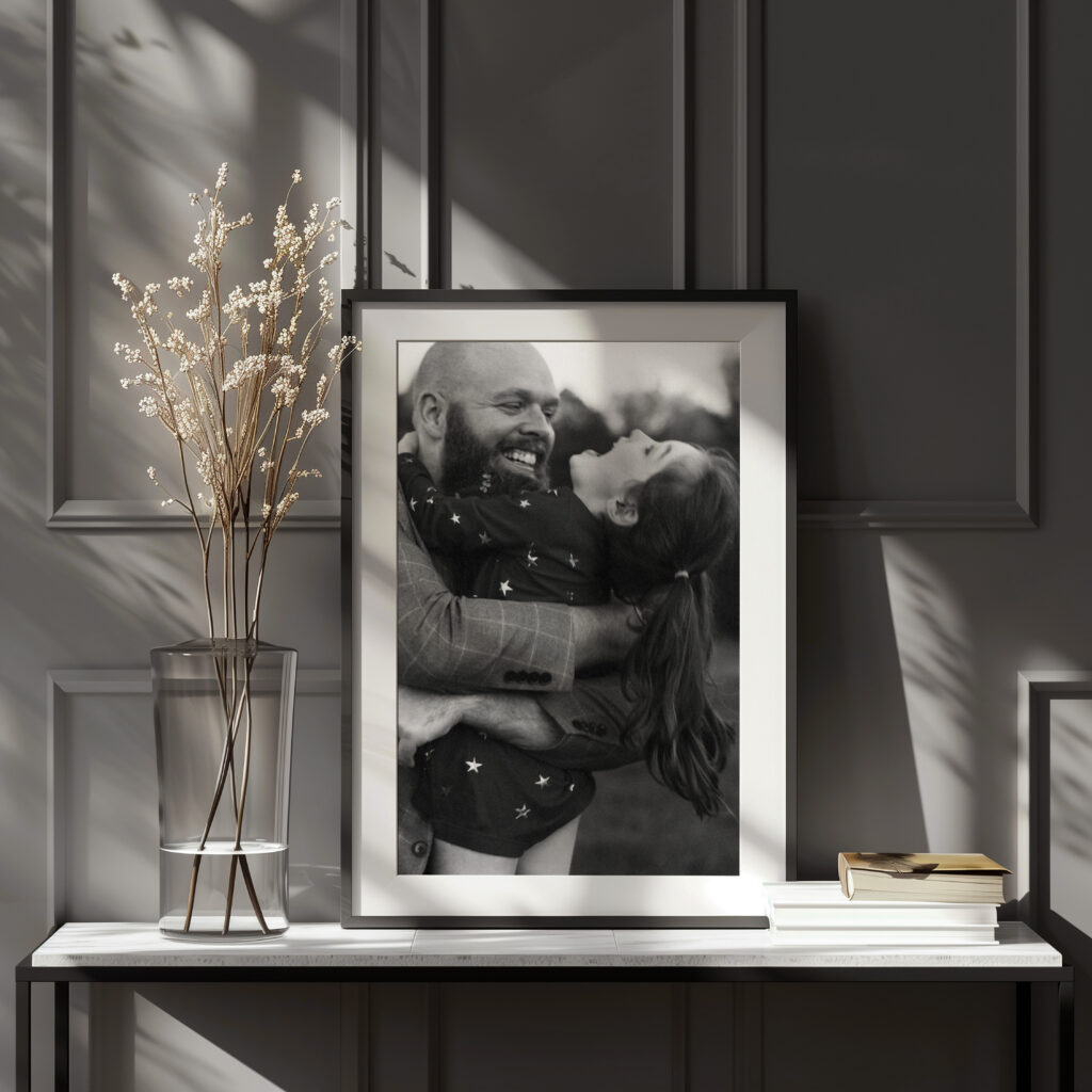 framed wall art of dad holding laughing daughter in black and white